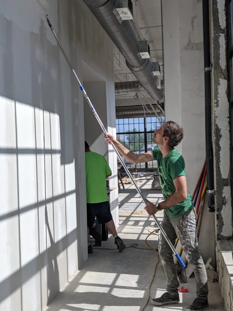 Aaron painting the walls of the new Ash & Elm Space